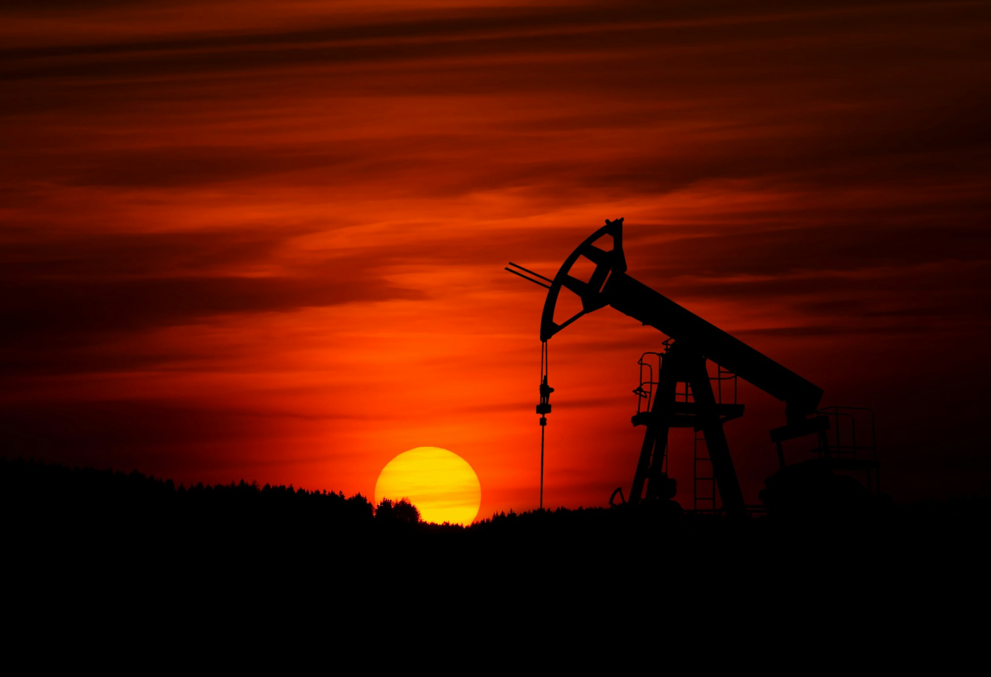 Oil pumpjack at sunset, illustrative stock photograph